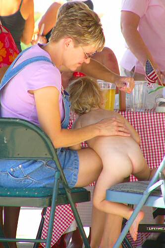 Mom applies sun block to baby bottom